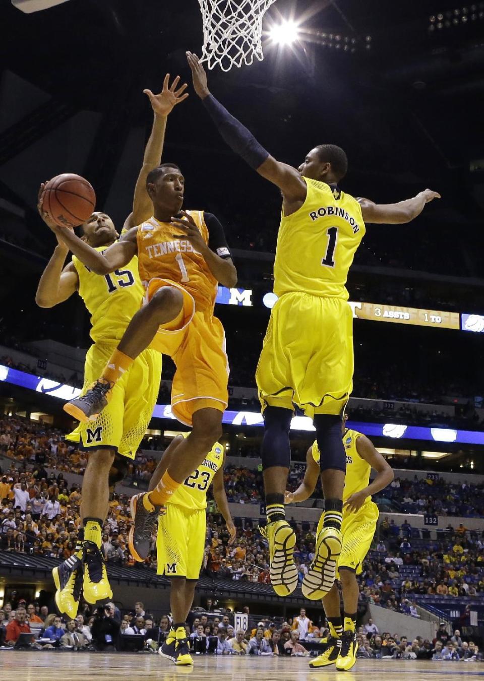 Tennessee's Josh Richardson passes around Michigan's Glenn Robinson III (1) and Jon Horford (15) during the first half of an NCAA Midwest Regional semifinal college basketball tournament game Friday, March 28, 2014, in Indianapolis. (AP Photo/Michael Conroy)