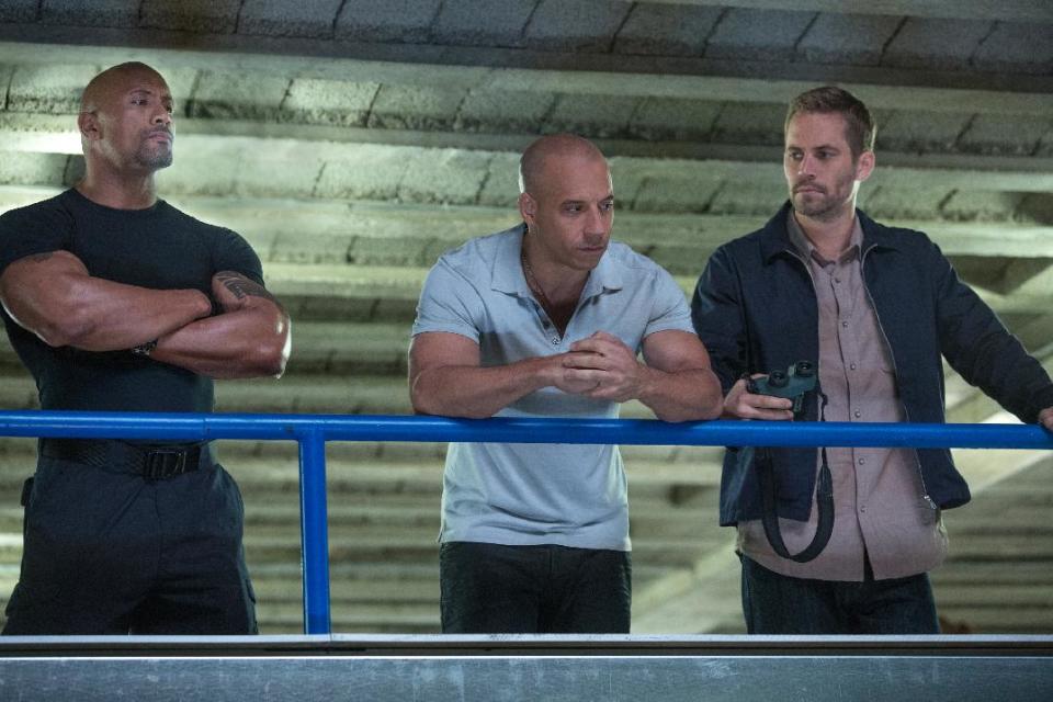 This film publicity image released by Universal Pictures shows Dwayne Johnson , left, Vin Diesel, center, and Paul Walker in a scene from "Fast & Furious 6." (AP Photo/Universal Pictures, Giles Keyte)