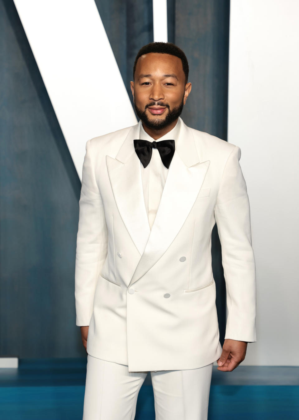 John Legend smiles while posing at a Hollywood event