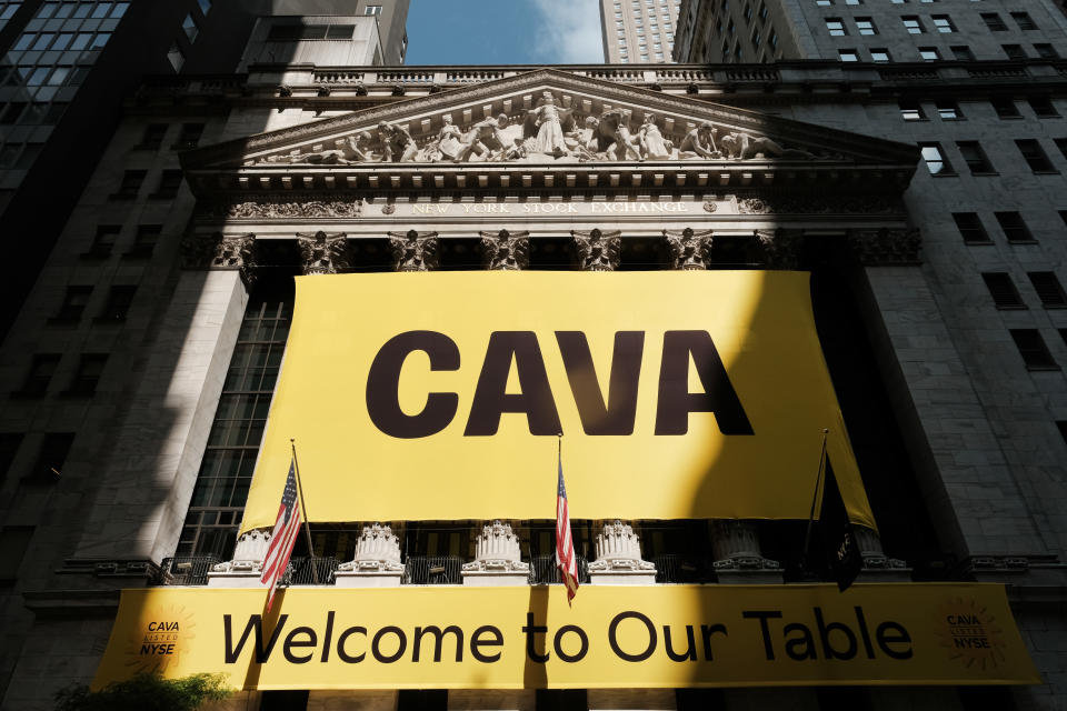 NEW YORK, NEW YORK - JUNE 15: A banner for the Mediterranean restaurant chain Cava is displayed outside of the New York Stock Exchange (NYSE) as the company goes public on June 15, 2023 in New York City.  Cava priced its IPO at $22 per share, valuing the company at $2.5 billion.  (Photo by Spencer Platt/Getty Images)