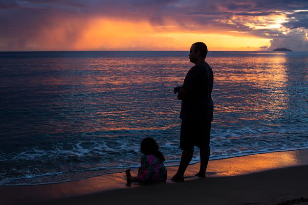 People observe the sunset at Los Almendros beach in Rincón, Puerto Rico, on Aug. 2. (Photo: Erika P. Rodriguez for HuffPost)