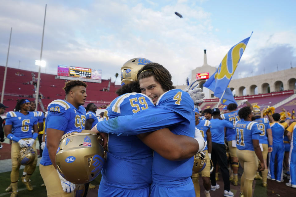 UCLA quarterback Ethan Garbers (4) and UCLA offensive lineman Siale Taupaki (59) celebrate after a 38-20 win over Southern California in an NCAA college football game in Los Angeles, Saturday, Nov. 18, 2023. (AP Photo/Ashley Landis)
