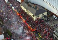 An aerial view of open-top busses carrying Wrexham players passes the Racecourse Ground, home of Wrexham, during a victory parade in Wrexham, Wales, Tuesday, May 2, 2023. The Welsh soccer team owned by Hollywood stars Ryan Reynolds and Rob McElhenney marked their promotion to the fourth division of English soccer with a bus parade through the city. The celebrity owners will reportedly jet the team off to Las Vegas as a reward for winning the National League with a record total of 111 points. (Martin Rickett/PA via AP)