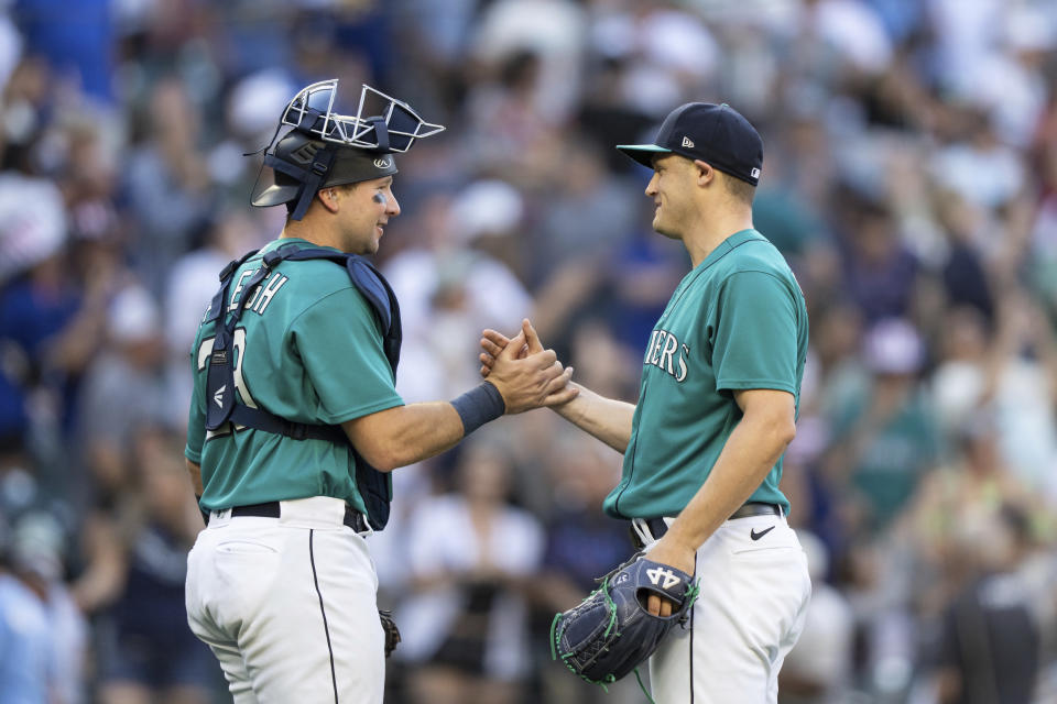 Seattle Mariners relief pitcher Paul Sewald, right, and catcher Cal Raleigh celebrate the team's win in a baseball game against the Tampa Bay Rays, Saturday, July 1, 2023, in Seattle. The Mariners won 8-3. (AP Photo/Stephen Brashear)