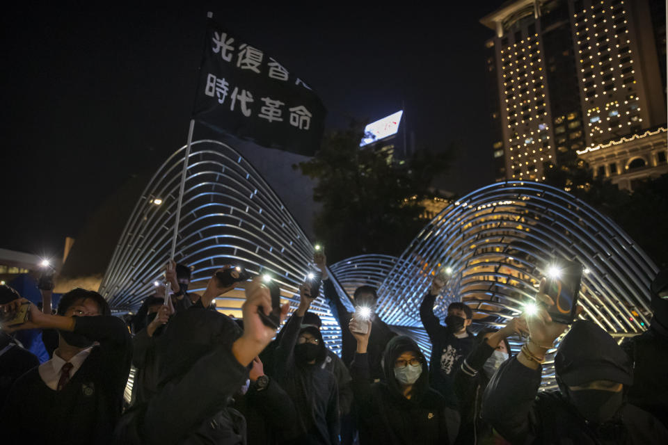 Protesters wave their smartphones as they sing "Glory to Hong Kong" during a rally for secondary school students near the Hong Kong Museum of Art in Hong Kong, Friday, Dec. 13, 2019. Protesters in Hong Kong wrote hundreds of Christmas cards on Thursday for people jailed in the city's pro-democracy movement, promising they won't be forgotten as they face spending the festive season behind bars. (AP Photo/Mark Schiefelbein)