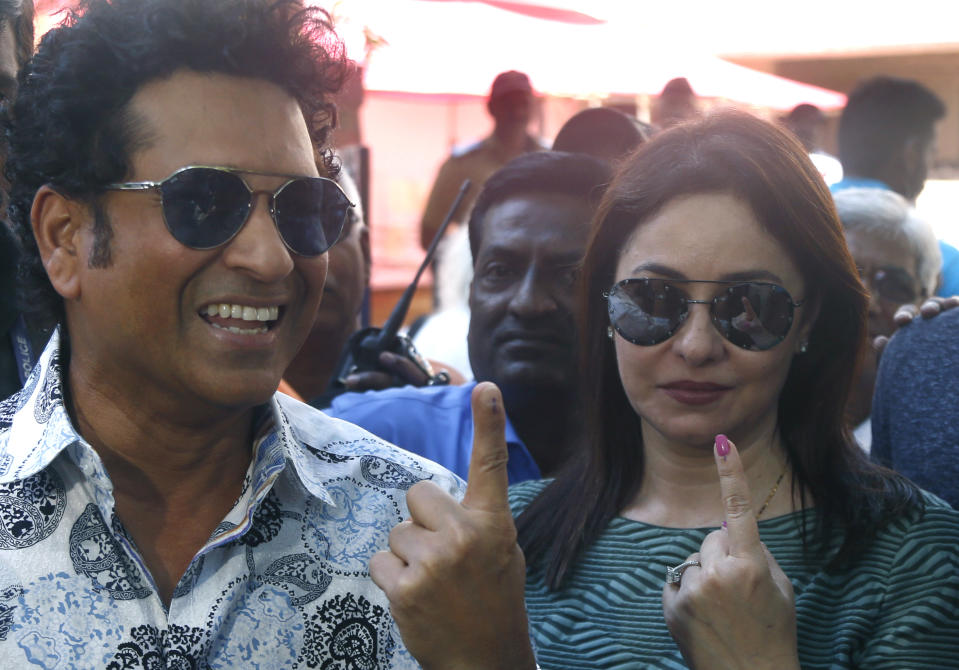 Former Indian cricketer Sachin Tendulkar, left, with his wife Anjali pose for media after casting their votes in Mumbai, India, Monday, Oct. 21, 2019. Voting is underway in two Indian states of Maharashtra in the west and Haryana in the north where the Hindu nationalist Bharatiya Janata Party (BJP) headed by prime minister Narendra Modi is trying to win a second consecutive term. (AP Photo/Rafiq Maqbool)