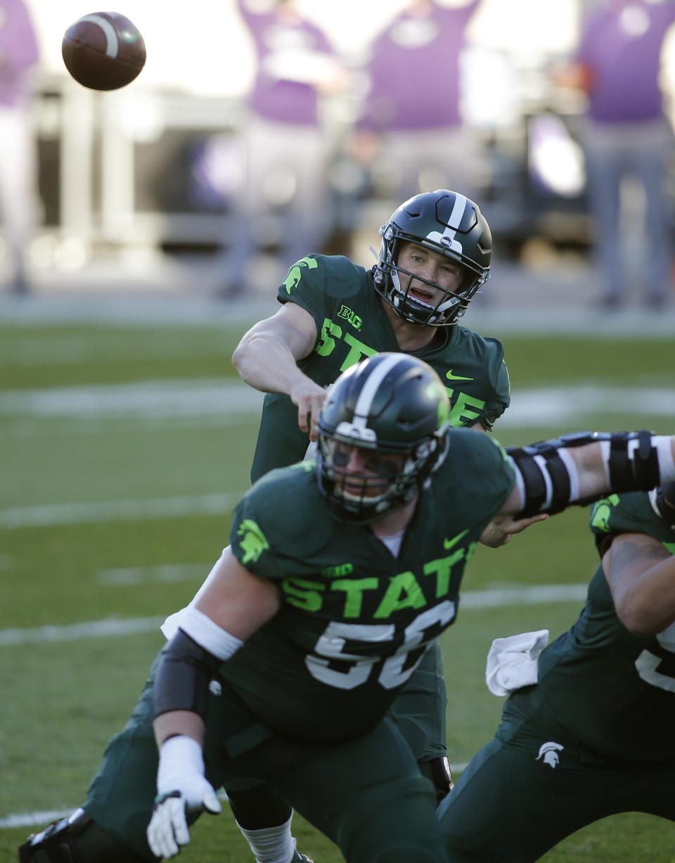 Michigan State quarterback Rocky Lombardi, top, throws a pass as guard Matt Carrick blocks against Northwestern during the first quarter of an NCAA college football game, Saturday, Nov. 28, 2020, in East Lansing, Mich. (AP Photo/Al Goldis)