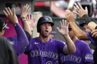 Colorado Rockies' Ryan McMahon is congratulated by teammates in the dugout after scoring on a single by Elias Diaz during the third inning of a baseball game against the Los Angeles Angels Tuesday, July 27, 2021, in Anaheim, Calif. (AP Photo/Mark J. Terrill)