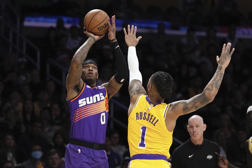 Phoenix Suns forward Torrey Craig, left, shoots as Los Angeles Lakers guard D'Angelo Russell defends during the first half of an NBA basketball game Wednesday, March 22, 2023, in Los Angeles. (AP Photo/Mark J. Terrill)