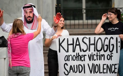 A demonstrator dressed as Saudi Arabian Crown Prince Mohammed bin Salman (C) with blood on his hands protests with others outside the Saudi Embassy in Washington - Credit: JIM WATSON/AFP/Getty Images