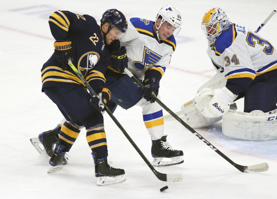 Buffalo Sabres forward Johan Larsson (22) and St. Louis Blues defenseman Vince Dunn (29) battle for the puck during the first period of an NHL hockey game, Tuesday, Dec. 10, 2019, in Buffalo, N.Y. (AP Photo/Jeffrey T. Barnes)