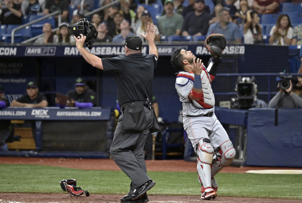 Uumpire Dan Bellino, left, signals a foul ball as Washington Nationals catcher Keibert Ruiz waits for a pop fly that got stuck in the catwalk during the first inning of a baseball game Saturday, June 29, 2024, in St. Petersburg, Fla. (AP Photo/Steve Nesius)