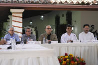 Members of the Colombian guerrilla National Liberation Army (ELN), from left, Aureliano Carbonel, Pablo Beltran and Antonio Garcia sit with Ivan Danilo Rueda, High Commissioner for Peace on behalf of the Colombian government, second from right, and government representative Ivan Cepeda, during a signing ceremony agreeing to resume peace talks, at the Casa Cultural Aquiles Nazoa in Caracas, Venezuela, Tuesday, Oct. 4, 2022. The agreement comes after more than four years of suspension, and will start in November. (AP Photo/Ariana Cubillos)