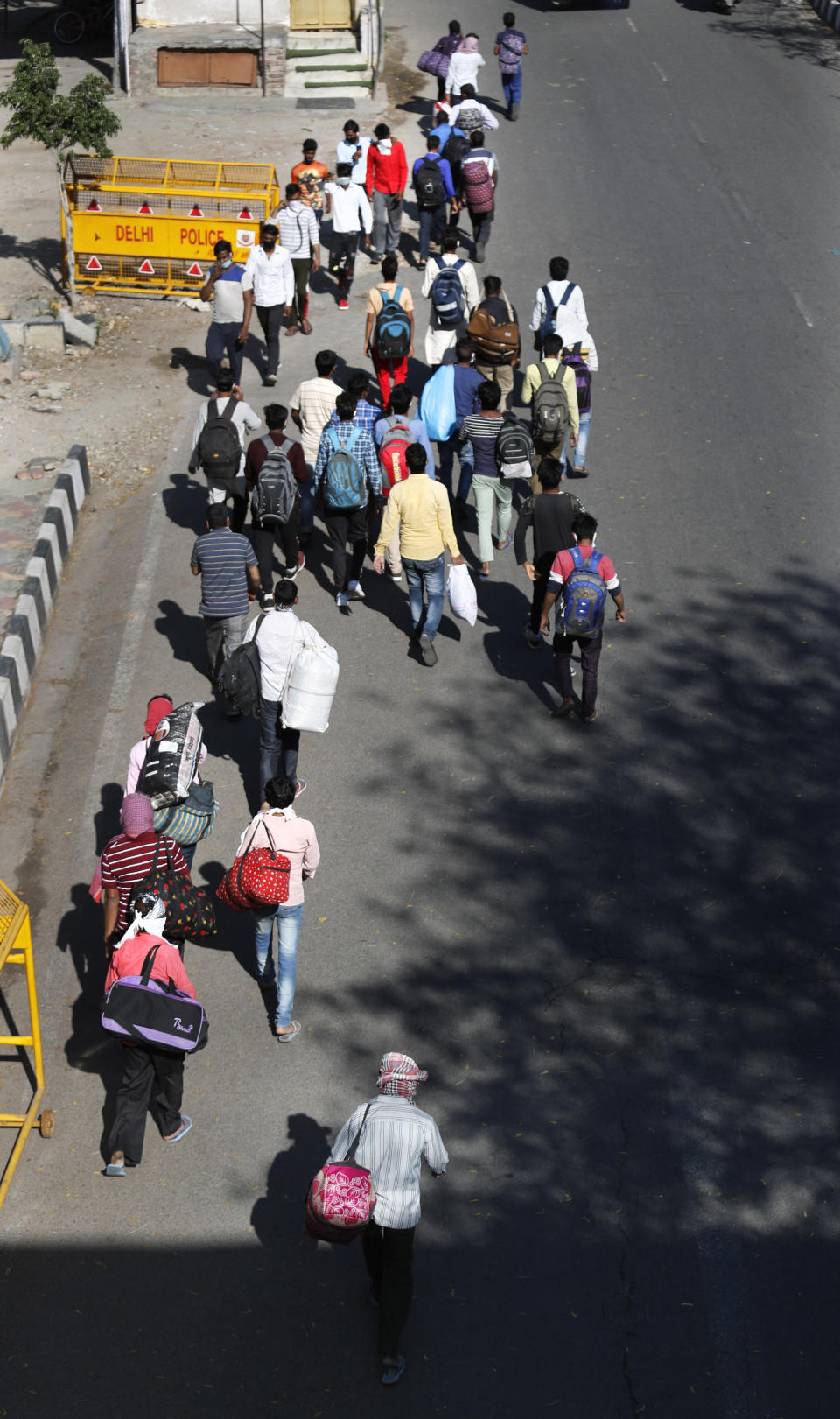 Migrant daily wage laborers make the journey to their respective villages on foot following a lockdown amid concern over spread of coronavirus in New Delhi, India, Friday, March 27, 2020. Some of India's legions of poor and others suddenly thrown out of work by a nationwide stay-at-home order began receiving aid on Thursday, as both public and private groups worked to blunt the impact of efforts to curb the coronavirus pandemic. The measures that went into effect Wednesday, the largest of their kind in the world, risk heaping further hardship on the quarter of the population who live below the poverty line and the 1.8 million who are homeless. (AP Photo/Manish Swarup)