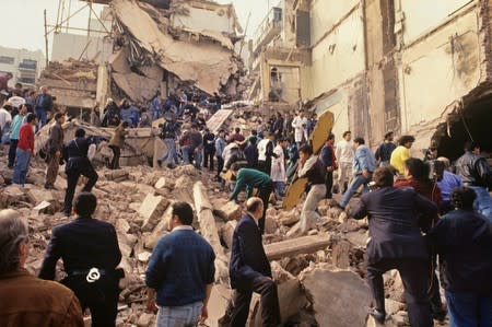 Rescue workers work after an explosives-laden truck blew up outside the Argentine Israeli Mutual Association (AMIA) building on July 18 1994, in Buenos Aires