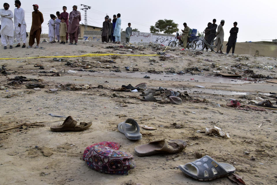 Residentes de pie en el sitio donde un atacante suicida se inmoló cerca de Quetta, Pakistán, el viernes 29 de septiembre de 2023. (AP Foto/Arshad Butt)