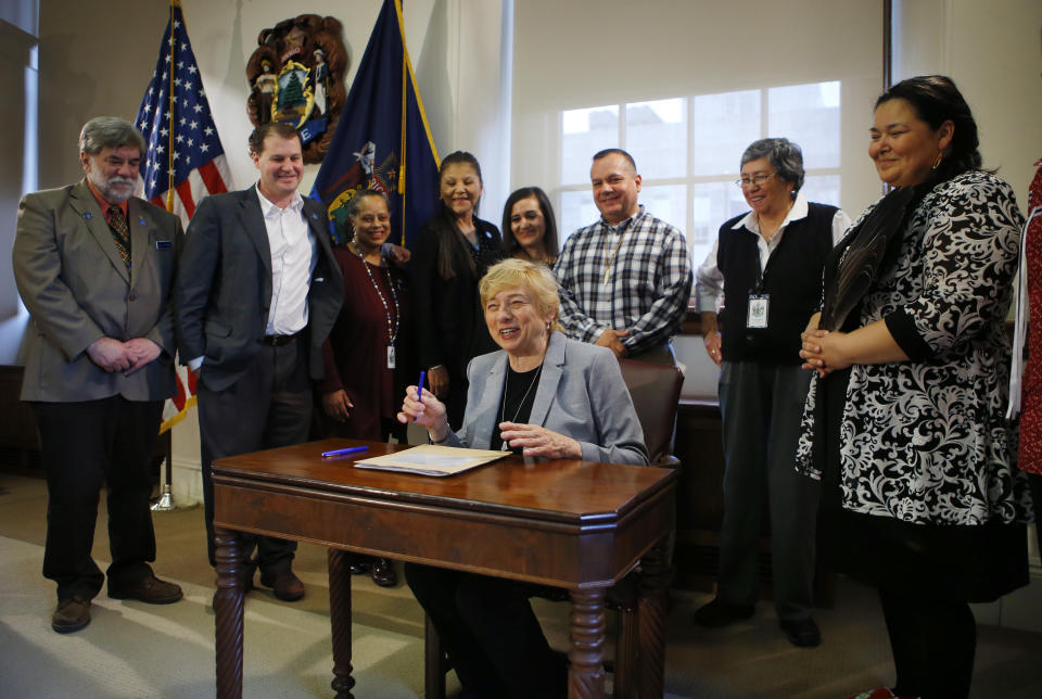 Maine Gov. Janet Mills signs a bill to establish Indigenous Peoples' Day, Friday, April 26, 2019, at the State House in Augusta, Maine. Mills added Maine to the growing number of states changing Columbus Day to Indigenous Peoples' Day. (AP Photo/Robert F. Bukaty)