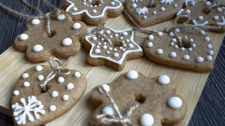 Cinnamon ornaments with twine hangers on a wooden board