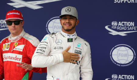 Formula One - F1 - Brazilian Grand Prix - Circuit of Interlagos, Sao Paulo, Brazil - 12/11/2016 - Mercedes' Lewis Hamilton of Britain (R) celebrates pole position next to Ferrari's Formula One driver Kimi Raikkonen of Finland. REUTERS/Paulo Whitaker