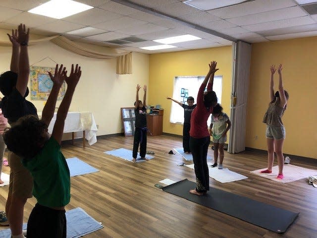 Church members and children at St. Gregory the Great Episcopal Church practice yoga together. Courtesy of Doug Adkins.