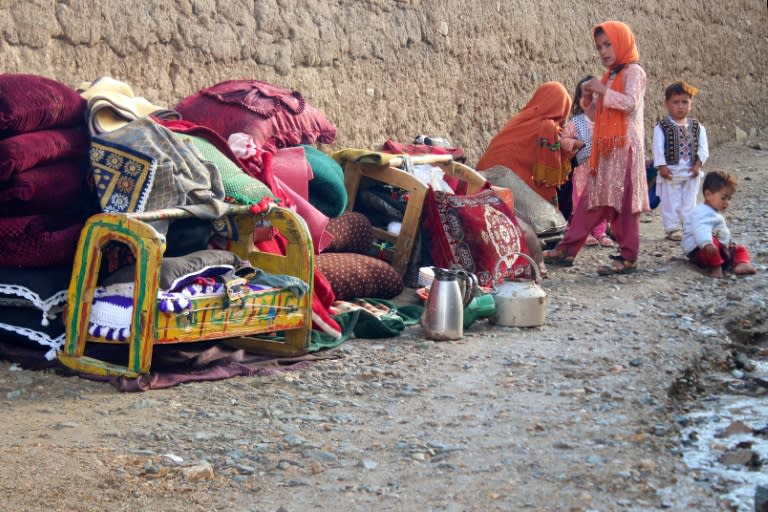 Une femme afghane et des enfants, près d'une maison endommagée par une crue soudaine et meurtrière, à Firozkoh, le 18 mai 2024 (-)