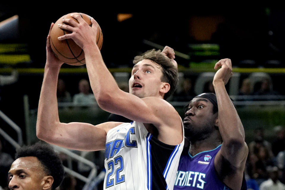 Orlando Magic forward Franz Wagner (22) gets off a shot in front of Charlotte Hornets center Mark Williams, right, during the first half of an NBA basketball game, Sunday, Nov. 26, 2023, in Orlando, Fla. (AP Photo/John Raoux)