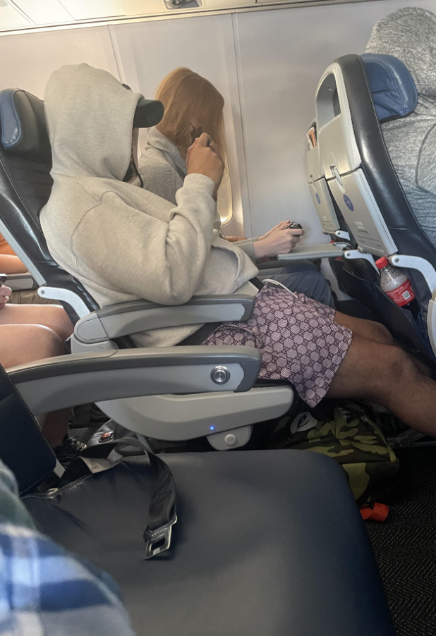 A person on a plane watching a movie on their phone