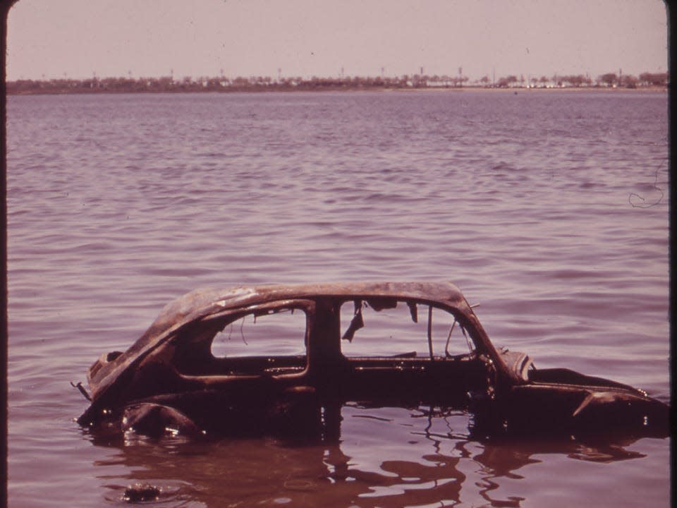 An abandoned car sits in Jamaica Bay in New York City in 1973. Landfills and auto salvage yards fall under the EPA's regulations now, though improper disposal still occurs.