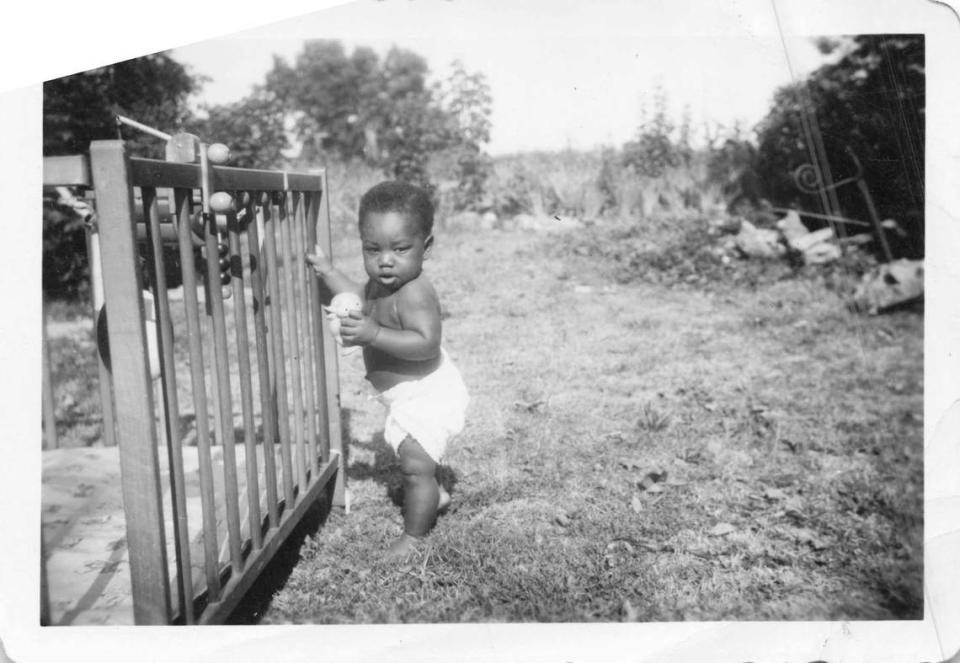 A photo of Larry Jackson Jr. as a baby, standing next to a crib. Raised as an only child in Kansas City, Kansas, he considered the people on his block to be like family.