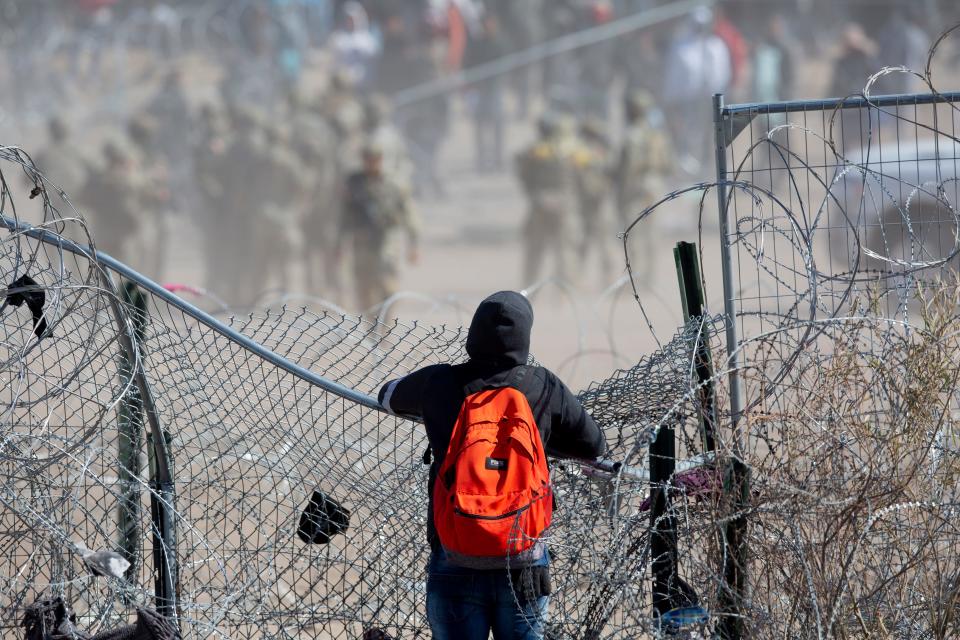A migrant observes migrants who breached the concertina wire on the Rio Grande in El Paso, Texas on March 21, 2024. The migrants were hoping to be processed by Border Patrol.