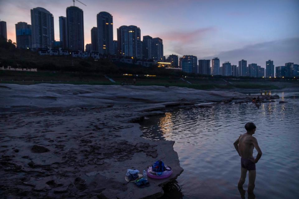 A man stands in shallow water near the dry riverbed of the Yangtze River in southwestern China (AP)