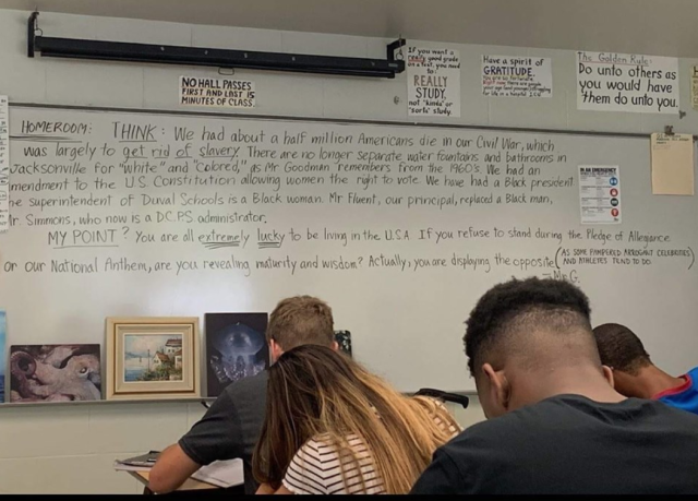 Stylish African American female coach, stands at whiteboard, in