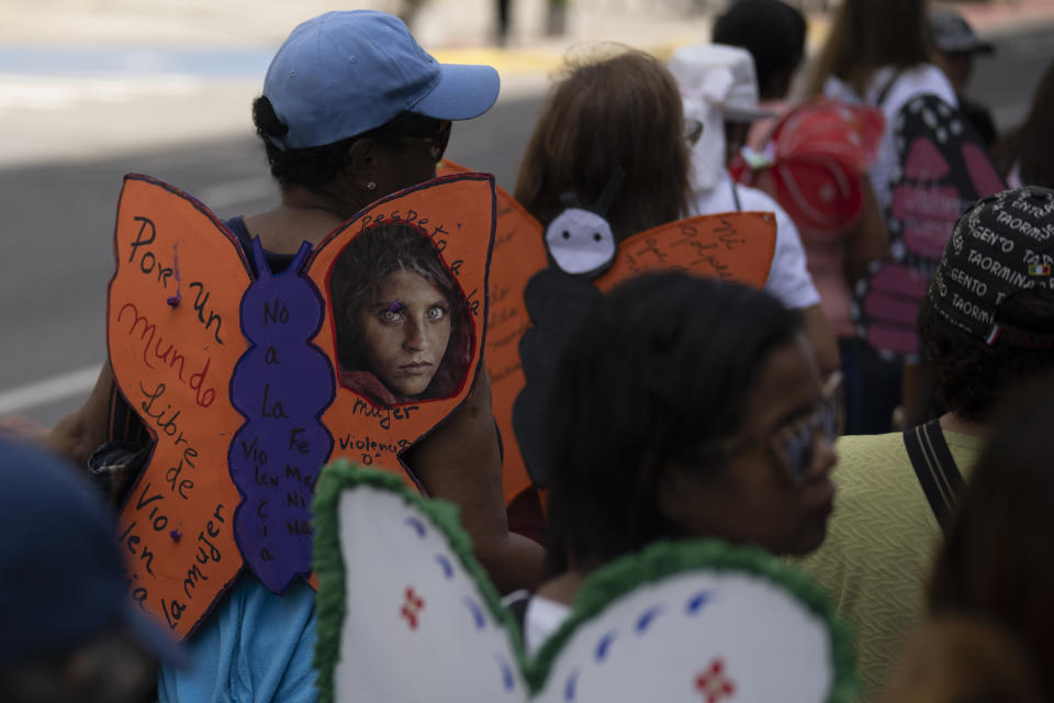 Una mujer luce alas de mariposa de papel con un mensaje que dice "Por un mundo libre de violencia contra la mujer", durante una marcha para conmemorar el Día Internacional de la Eliminación de la Violencia contra las Mujeres, en Caracas, Venezuela, el sábado 25 de noviembre. 2023. (Foto AP/Ariana Cubillos)