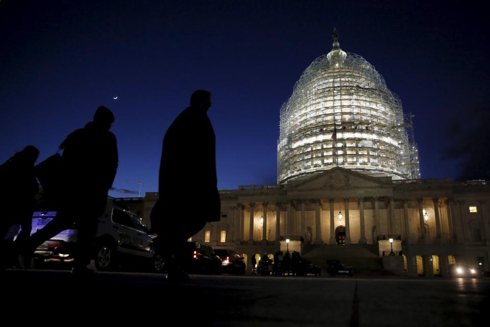 People walk past the U.S. Capitol dome in the hours before President Barack Obama delivers the State of the Union address to a joint session of Congress in Washington January 12, 2016. REUTERS/Jonathan Ernst