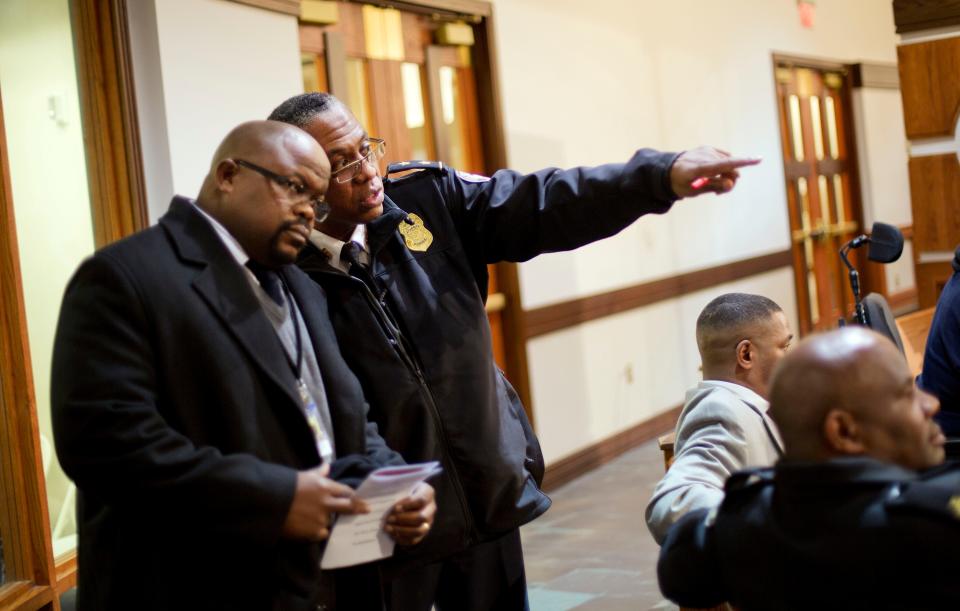 Samuel Lee Reid, executive director of the Atlanta Citizen Review Board, left, talks with Atlanta Police Deputy Chief Ernest Finley during a community town hall  in Atlanta in this 2014 photo. Before moving to Atlanta, Reid worked on police reform efforts in Minnesota.