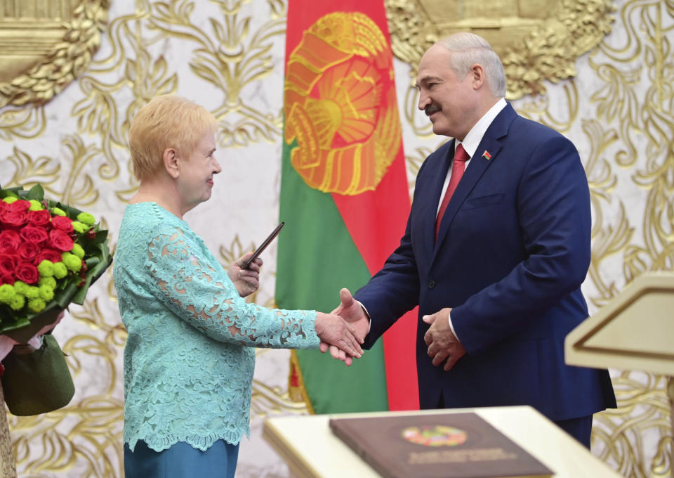 Central Elections Commission Chairwoman Lidiya Ermoshina, left, and Belarusian President Alexander Lukashenko shake hands during his inauguration ceremony at the Palace of the Independence in Minsk, Belarus, Wednesday, Sept. 23, 2020. Lukashenko of Belarus has assumed his sixth term of office in an inauguration ceremony that wasn't announced in advance. State news agency BelTA reports that the ceremony will take place with several hundred top government official present. (Andrei Stasevich/Pool Photo via AP)