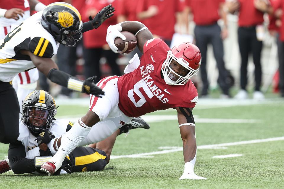 Arkansas Razorbacks running back Raheim Sanders (5) rushes in the first quarter as an Arkansas Pine Bluff Golden Lions defender makes a tackle at War Memorial Stadium.