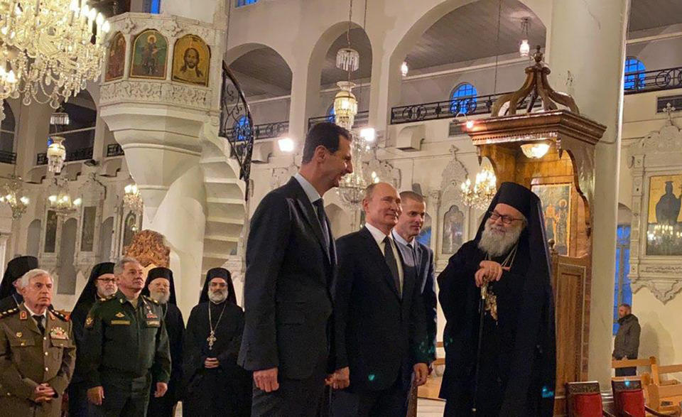 This image released by the Syrian Presidency, shows Russian President Vladimir Putin, third right, and Syrian President Bashar Assad, center, visiting an orthodox cathedral for Christmas, in Damascus, Syria, Tuesday, Jan. 7, 2020. Putin's visit is the second to the war-torn country where his troops have been fighting alongside Syrian government forces since 2015. (Syrian Presidency via AP)