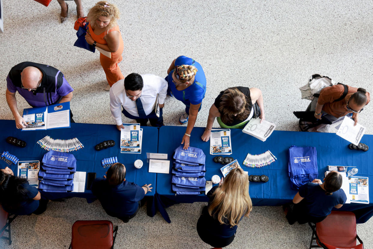 A shot from above of job seekers at an information table. (Joe Raedle / Getty Images file)