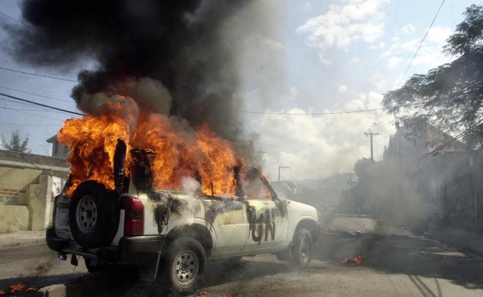 A U.N. mission car is burned by demonstrators in Haiti on Dec. 20, 2006. <a href="https://www.gettyimages.co.uk/detail/news-photo/port-au-prince-haiti-a-un-mission-car-is-burned-20-december-news-photo/72879260?adppopup=true" rel="nofollow noopener" target="_blank" data-ylk="slk:Thony Belizaire/AFP via Getty Images;elm:context_link;itc:0;sec:content-canvas" class="link ">Thony Belizaire/AFP via Getty Images</a>