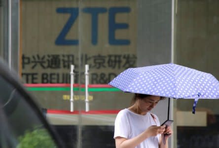 FILE PHOTO: A woman stands outside a building of ZTE Beijing research and development center in Beijing, China June 13, 2018. REUTERS/Jason Lee