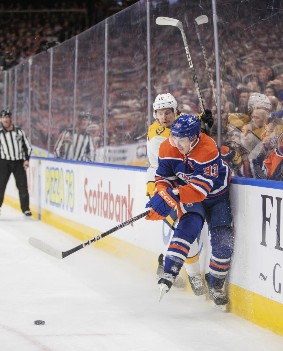 Nashville Predators' Denis Gurianov (15) battles Edmonton Oilers' Ryan Nugent-Hopkins (93) during second-period NHL hockey game action in Edmonton, Alberta, Saturday, Jan. 27, 2024. (Amber Bracken/The Canadian Press via AP)