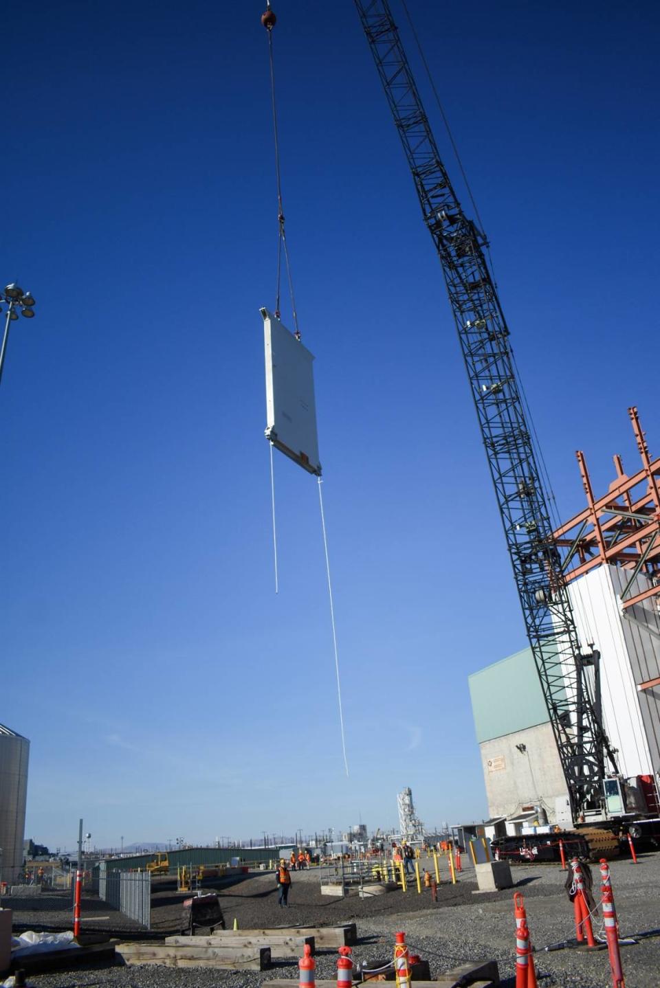 Some limited construction work is being done at the Hanford vitrification plant’s High Level Waste Facility, including “flying” 16-ton carbon steel shield doors into the building with a crane.