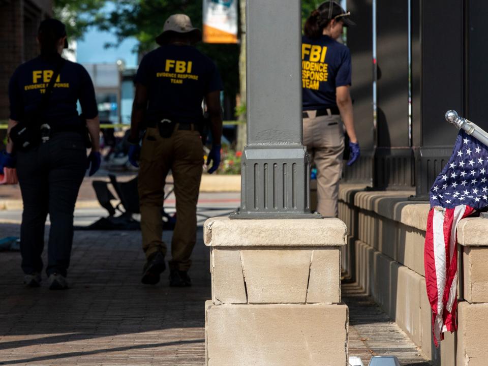 Backs of FBI agents next to US flag