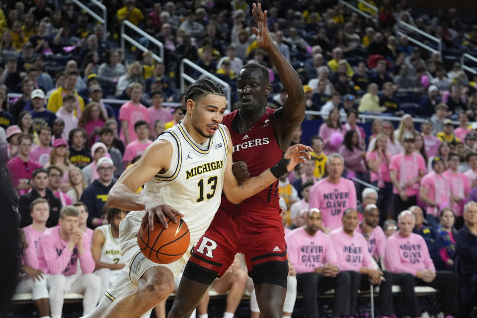 Michigan forward Olivier Nkamhoua (13) drives on Rutgers forward Mawot Mag (3) in the second half of an NCAA college basketball game in Ann Arbor, Mich., Saturday, Feb. 3, 2024. (AP Photo/Paul Sancya)