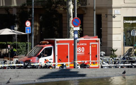 A policeman stands next to an ambulance after a van ploughed into the crowd, injuring several persons