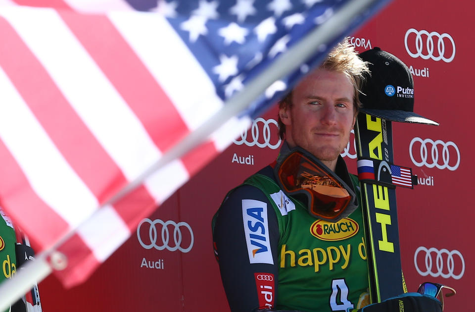 Ted Ligety of the United States listens to the national anthem after winning an alpine ski men's World Cup giant slalom, in Kranjska Gora, Slovenia, Saturday, March 8, 2014. (AP Photo/Giovanni Auletta)