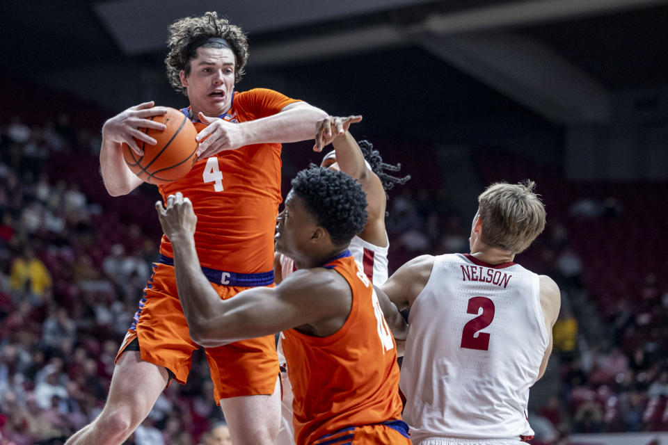 Clemson forward Ian Schieffelin (4) rebounds the ball against Alabama during the first half of an NCAA college basketball game, Tuesday, Nov. 28, 2023, in Tuscaloosa, Ala. Also pictured are Clemson forward RJ Godfrey and Alabama forward Grant Nelson (2). (AP Photo/Vasha Hunt)