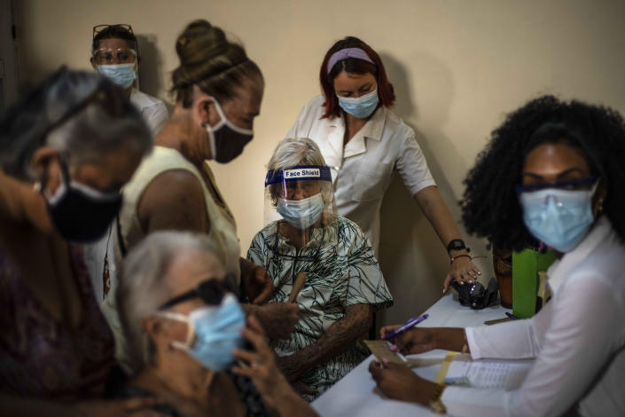 FILE - In this June 23, 2021 file photo, people sign up for a dose of the Cuban Abdala COVID-19 vaccine in Havana, Cuba. Cuba has been trying to rapidly roll out the two vaccines that it has approved for massive use, Abdala and Soberana, both of which require three jabs. (AP Photo/Ramon Espinosa, File)