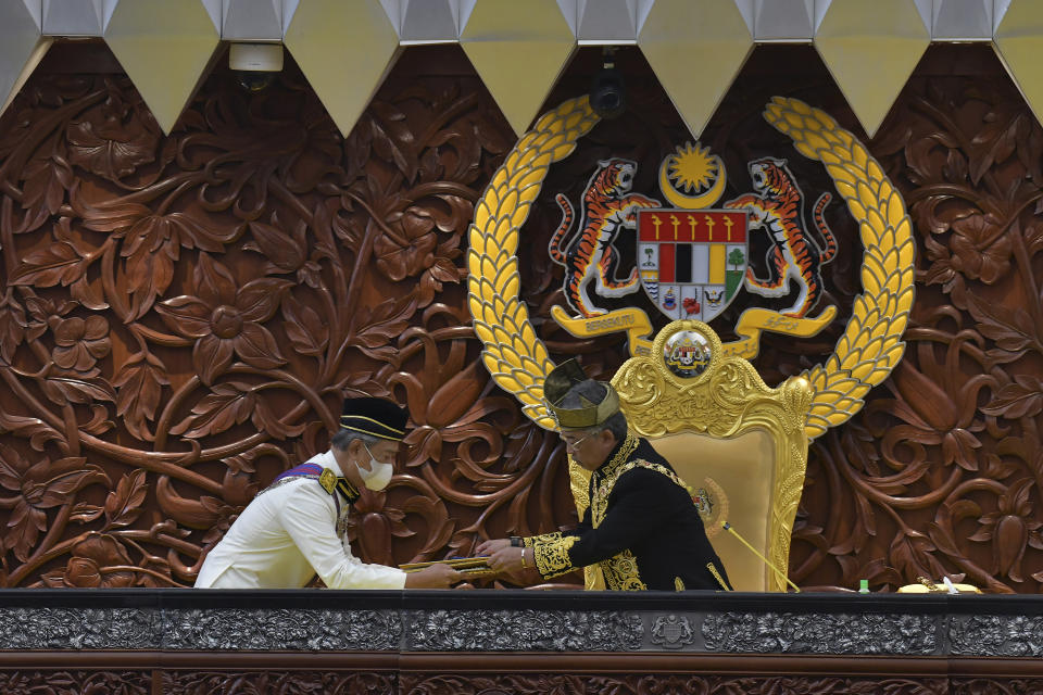 In this photo released by Malaysia's Department of Information, Malaysia's King Sultan Abdullah Sultan Ahmad Shah, right, receives documents from Prime Minister Muhyiddin Yassin during the opening ceremony of the third term of the 14th parliamentary session at parliament house in Kuala Lumpur Monday, May 18, 2020. Malaysia’s King on Wednesday, June 16, 2021, said that Parliament, which has been suspended under a coronavirus emergency since January, must resume as soon as possible. (Nazri Rapai/Malaysia's Department of Information via AP)